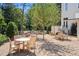 Charming outdoor dining area with wooden furniture surrounded by lush greenery and gravel at 100 Sheridan Dr, Atlanta, GA 30305