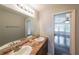 Bathroom featuring a double sink vanity and framed mirror, looking to a bedroom with many windows at 180 Old Airport Rd, Carrollton, GA 30116