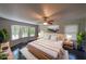 Staged primary bedroom features a ceiling fan, hardwood floors and windows with a wooded view at 180 Old Airport Rd, Carrollton, GA 30116