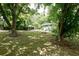 Lush backyard featuring a covered patio, fire pit, and an outbuilding nestled amongst mature trees at 139 Merritt Se St, Marietta, GA 30060