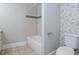 Well-lit bathroom features a tub and shower with tile surround and stylish neutral-toned wallpaper at 139 Merritt Se St, Marietta, GA 30060