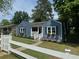 Charming blue home featuring a well-maintained yard, a white picket fence, and blooming flower boxes at 139 Merritt Se St, Marietta, GA 30060