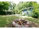 Cozy backyard fire pit area with seating under a covered patio, surrounded by mature trees and greenery at 139 Merritt Se St, Marietta, GA 30060