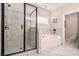 Well-lit bathroom with a glass-enclosed shower and separate soaking tub, complemented by elegant marble tiling at 30 Deer Creek Ct, Moreland, GA 30259