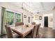 Elegant dining room with a stone table, a modern chandelier, and views of the lush green exterior at 30 Deer Creek Ct, Moreland, GA 30259