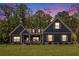Charming craftsman home with a manicured lawn and lush landscaping, set against a picturesque twilight sky at 30 Deer Creek Ct, Moreland, GA 30259