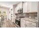 Modern kitchen featuring stainless steel appliances, granite countertops, and stylish white cabinets, perfect for cooking at 30 Deer Creek Ct, Moreland, GA 30259