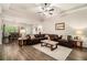 Spacious living room with hardwood floors, a ceiling fan, and a comfortable leather sofa set, exuding modern elegance at 30 Deer Creek Ct, Moreland, GA 30259