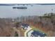 Aerial view of the home from behind showcasing lake and islands with long driveway and detached garage at 7625 Breeze Bay Rd, Cumming, GA 30041