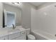 Bright bathroom with white vanity, tub with white tile surround and a large mirror at 7625 Breeze Bay Rd, Cumming, GA 30041