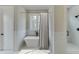 Bright bathroom showcasing a modern tub under a window and a marble-tiled shower with sleek black fixtures at 7625 Breeze Bay Rd, Cumming, GA 30041