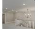Upper landing with view of living area with a chandelier and staircase with white railing at 7625 Breeze Bay Rd, Cumming, GA 30041