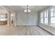 Open-concept dining room with large windows, hardwood floors, and a modern chandelier at 7625 Breeze Bay Rd, Cumming, GA 30041