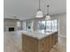Open concept eat-in kitchen with marble countertops, a wooden island, and a living room with a fireplace at 7625 Breeze Bay Rd, Cumming, GA 30041