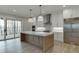 Bright kitchen with marble countertops, stainless steel appliances, and a kitchen island with a sink at 7625 Breeze Bay Rd, Cumming, GA 30041