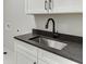 Close-up of laundry room with gray countertop, white cabinets and modern, black faucet at 7625 Breeze Bay Rd, Cumming, GA 30041