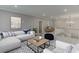 Spacious living room with white sectional, stylish decor, and staircase with white railings at 7625 Breeze Bay Rd, Cumming, GA 30041