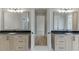 A spacious main bathroom with double vanity with stone countertops, wood cabinets, and a central doorway at 7625 Breeze Bay Rd, Cumming, GA 30041