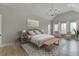 Light-filled main bedroom with a high ceiling, sitting area, and tasteful decor at 7625 Breeze Bay Rd, Cumming, GA 30041
