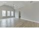 Spacious main bedroom with high ceilings, hardwood floors, and three large windows for ample natural light at 7625 Breeze Bay Rd, Cumming, GA 30041