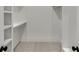Clean walk-in closet with white built-in shelving and soft carpet, offering a tidy storage solution at 7625 Breeze Bay Rd, Cumming, GA 30041