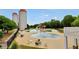 Large outdoor swimming pool area with a water slide, mushroom fountain, lounge chairs, and silo-shaped towers at 85 Foxgrove Cv, Covington, GA 30014