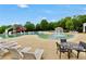 Outdoor pool with water slide and mushroom fountain; features lounge chairs and tables on concrete deck at 85 Foxgrove Cv, Covington, GA 30014