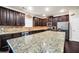 Well-equipped kitchen boasts dark wood cabinets, stainless steel appliances, and granite countertops at 85 Foxgrove Cv, Covington, GA 30014