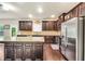 Stylish kitchen with stainless steel appliances, granite counters, dark cabinets, and hardwood floors at 85 Foxgrove Cv, Covington, GA 30014