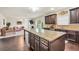 Open concept kitchen with a large island, stainless steel appliances, and dark wood cabinets at 85 Foxgrove Cv, Covington, GA 30014