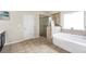 Bright bathroom with a standalone shower and tub area with large tiles and a window at 85 Foxgrove Cv, Covington, GA 30014