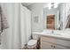 A clean bathroom featuring a vanity, toilet, and shower with a white curtain at , Atlanta, GA 30318