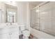 Bright bathroom featuring a white vanity, toilet, and a shower-tub combo with sliding glass doors at , Atlanta, GA 30318