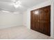 Cozy bedroom with tiled floors, a ceiling fan, natural light, and a large closet with stylish wood doors at 272 14Th St # 23, Atlanta, GA 30309