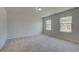 Bright bedroom features two windows, neutral carpet and light walls, providing a soothing ambiance at 2780 Dolce Rd, Dacula, GA 30019