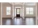 Bright foyer featuring dark hardwood floors, white trim, and a front door with glass panels at 2910 Hampton Grove Trce, Dacula, GA 30019