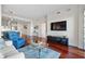 Spacious living area with a large TV, hardwood floors, and modern lighting fixtures at 2950 Mount Wilkinson Se Pkwy # 505, Atlanta, GA 30339