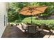Relaxing backyard deck with an umbrella, table, and chairs, perfect for outdoor entertaining or lounging at 5404 Trumpet Vine Se Trl, Mableton, GA 30126
