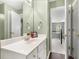 Bright bathroom with white vanity, framed mirror, and a view of the hallway and staircase at 5404 Trumpet Vine Se Trl, Mableton, GA 30126