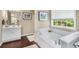 Bright bathroom with soaking tub, white cabinets, and picture window to backyard at 5404 Trumpet Vine Se Trl, Mableton, GA 30126