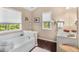 Bright bathroom with natural light, featuring a separate tub and stylish fixtures at 5404 Trumpet Vine Se Trl, Mableton, GA 30126