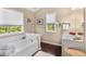 Bathroom featuring a tub, a sink, and natural light coming from the windows at 5404 Trumpet Vine Se Trl, Mableton, GA 30126