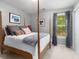 Bedroom with gray walls, wood-framed bed, and window with wooded views at 5404 Trumpet Vine Se Trl, Mableton, GA 30126