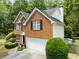 Aerial view of a two-story brick home with a well-manicured lawn and driveway at 5404 Trumpet Vine Se Trl, Mableton, GA 30126