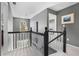 Hallway featuring gray walls, black and white banister, and an arched window providing natural light at 5404 Trumpet Vine Se Trl, Mableton, GA 30126