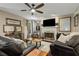Cozy living room with a fireplace, mounted TV, ceiling fan, and comfortable seating at 5404 Trumpet Vine Se Trl, Mableton, GA 30126