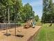 A playground features swings, slides, and play structures surrounded by trees, offering a safe and fun environment at 5404 Trumpet Vine Se Trl, Mableton, GA 30126