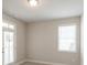 Light-filled bedroom features a door to the backyard, a window with blinds, and neutral walls at 5611 Meadowstone Walk, Kennesaw, GA 30152