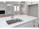 Modern kitchen island with stainless steel sink and faucet, overlooking the living room at 5611 Meadowstone Walk, Kennesaw, GA 30152