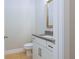 This powder room features a stylish vanity with a gray countertop, white cabinets, and modern black hardware at 5611 Meadowstone Walk, Kennesaw, GA 30152